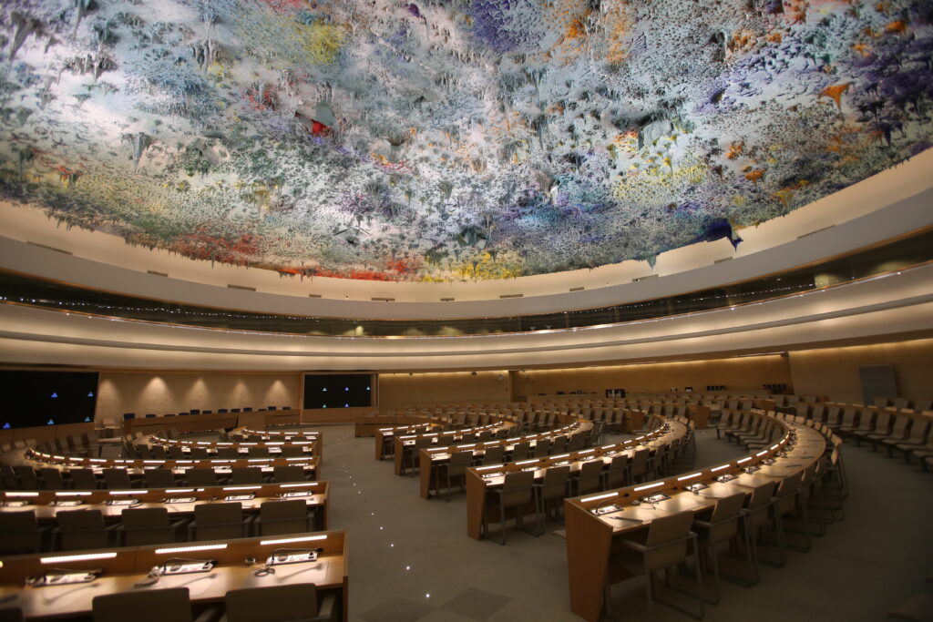 Photo: Human Rights and Alliance of Civilizations Room of the Palace of Nations, Geneva (Switzerland). It is the meeting room of the United Nations Human Rights Council. Author: Ludovic Court&egrave;s. Source: Wikicommons: https://commons.wikimedia.org/wiki/File:UN_Geneva_Human_Rights_and_Alliance_of_Civilizations_Room.jpg